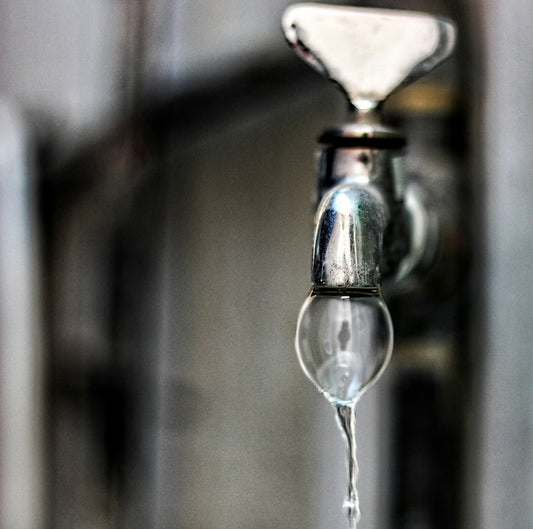 A close up of a faucet with water coming out of it